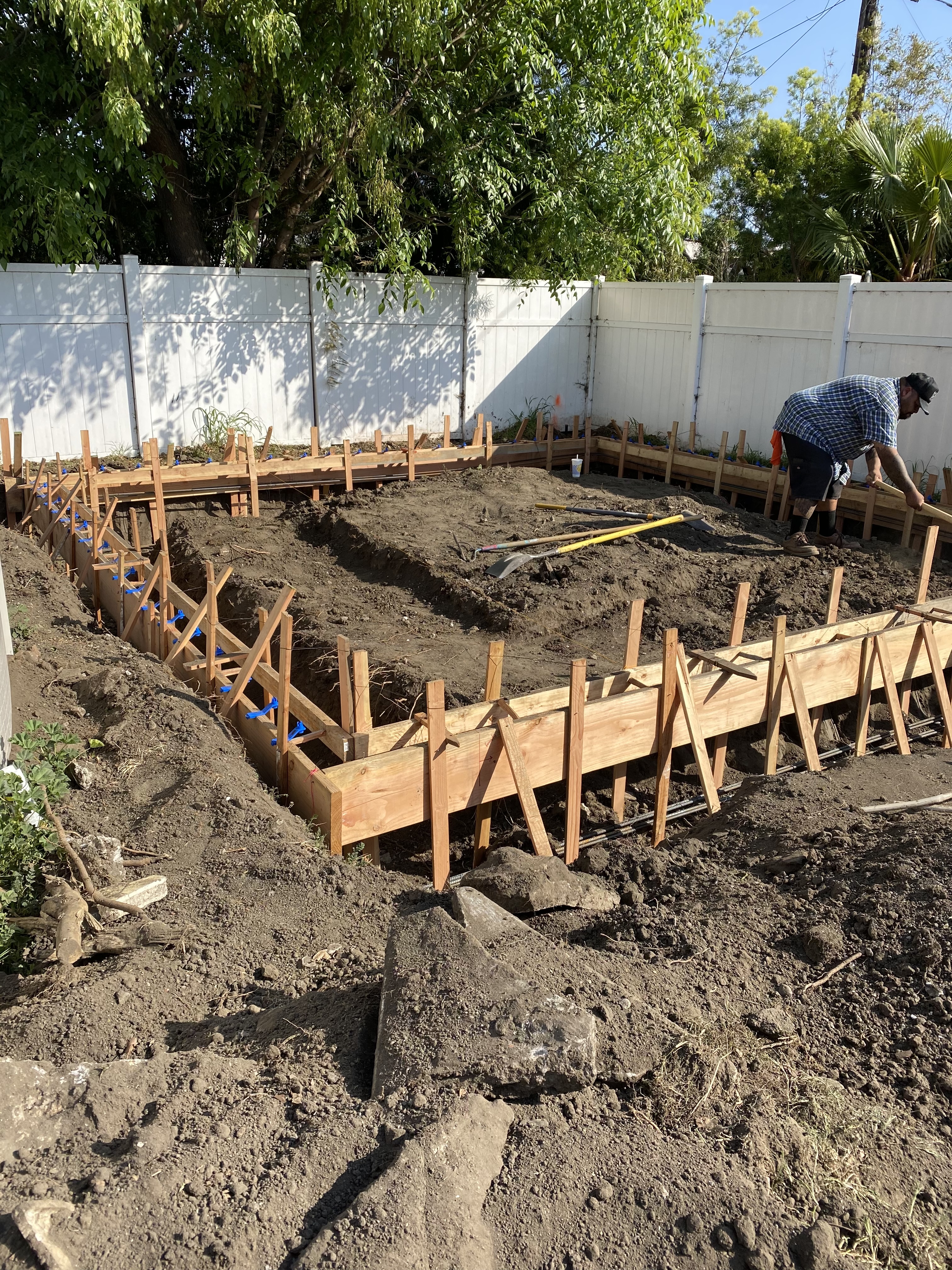 Image 1: An image of a man setting update a frame to pour concrete.  